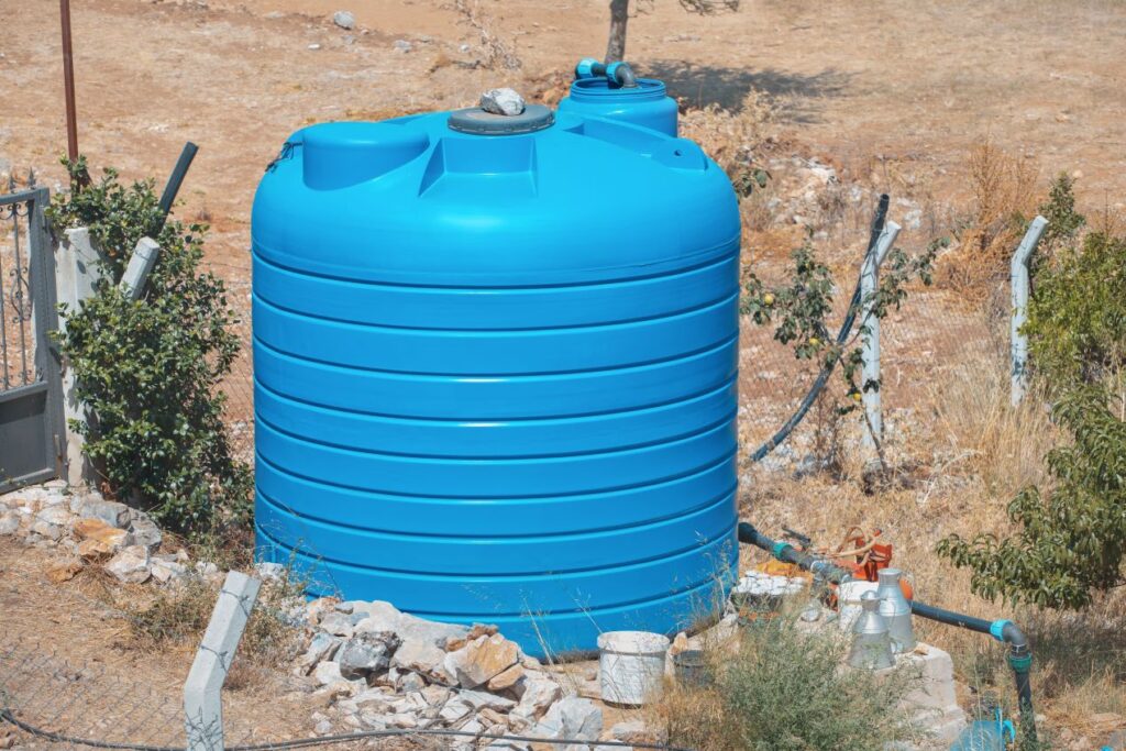 Blauer Regenwassertank flach im Garten – Wasser sparen durch nachhaltige Regenwassernutzung